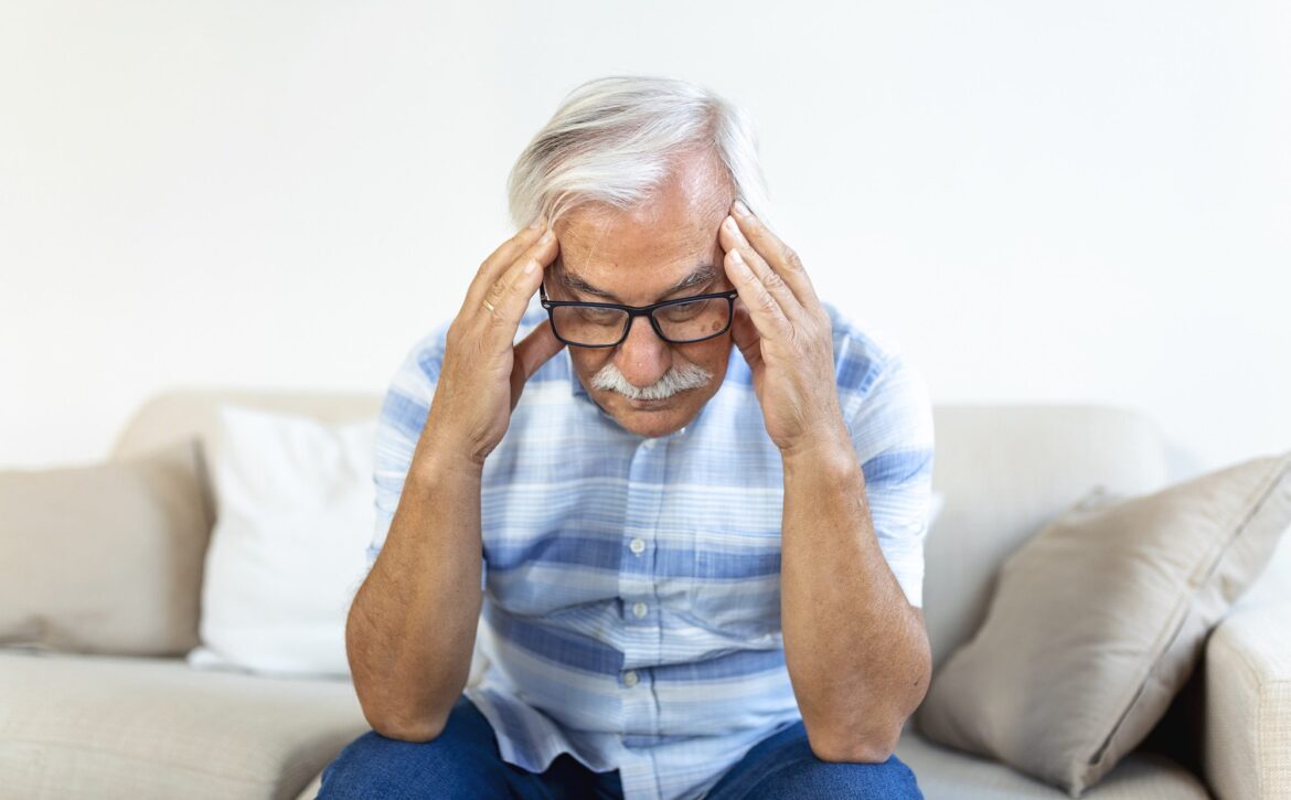 Attack of the monster migraine. Unhappy Retired Senior man holding his head with pain expression . Face of senior man suffering from headache