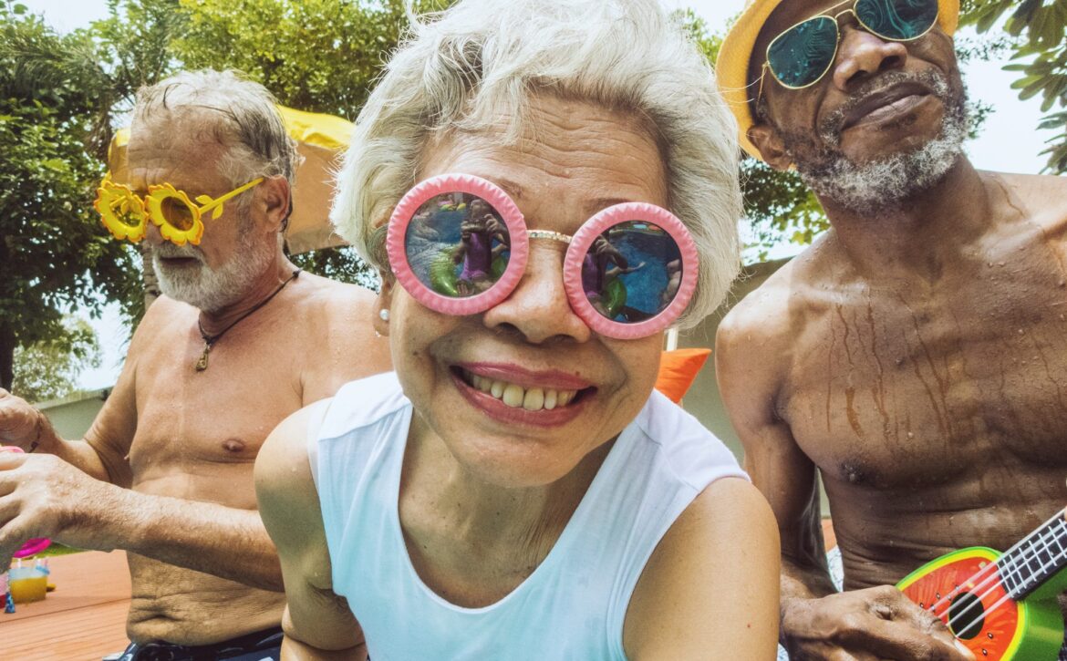 Closeup of diverse senior adults sitting by the pool enjoying summer together